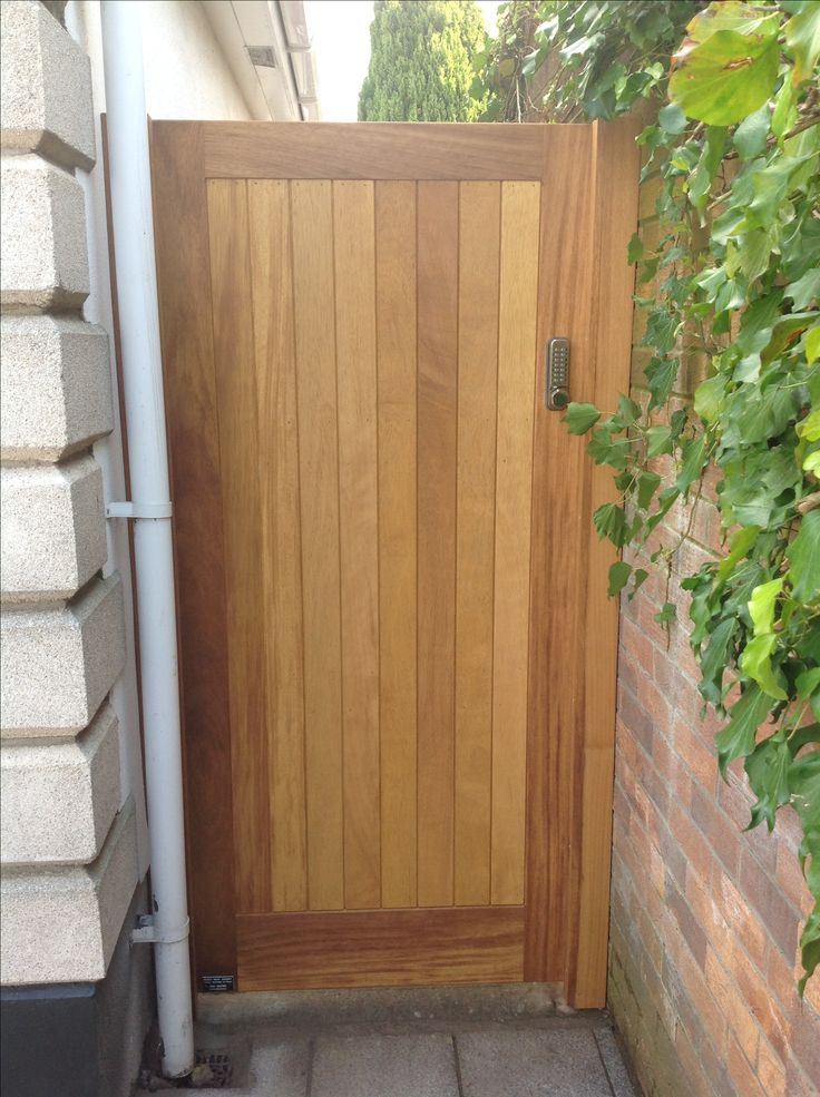 a wooden door is open in front of a brick wall