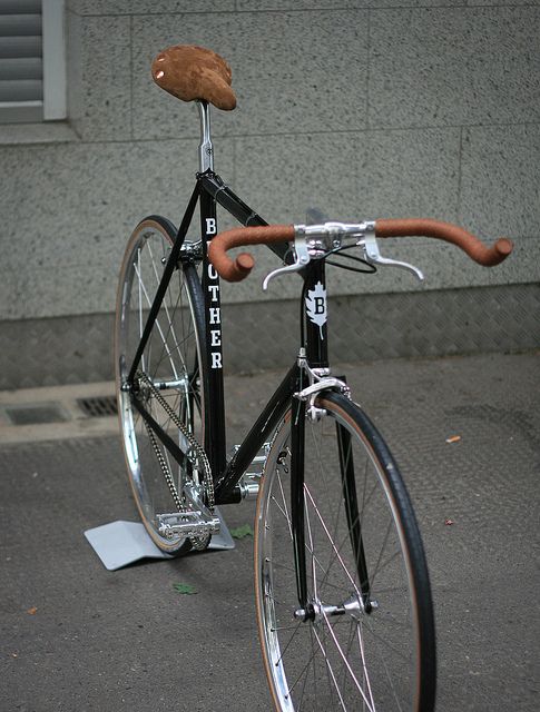 a black bike with a brown seat and handlebars