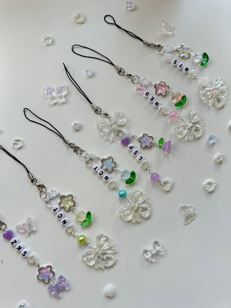 several necklaces are arranged on a white surface with beads and flowers in the middle