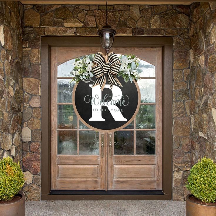 a front door decorated with wreaths and monogrammed letters for the letter r