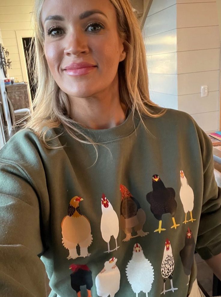 a woman wearing a sweater with chickens on it