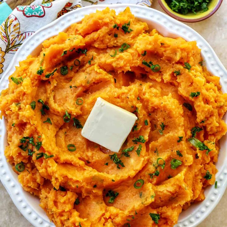 mashed sweet potatoes with butter and parsley on the side, ready to be eaten