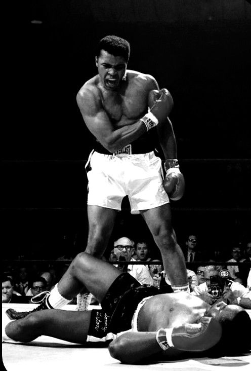 an old photo of a man wrestling with another man laying on the ground in front of him