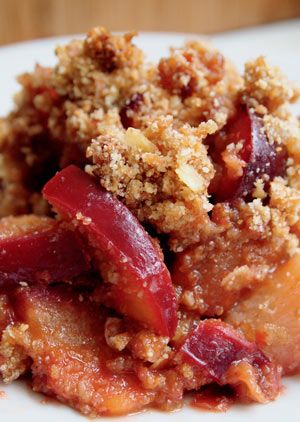 a close up of food on a plate with crumbs and fruit in it