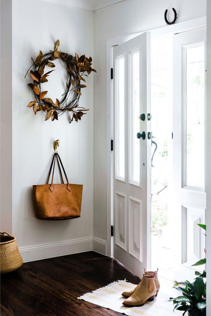 a door with a wreath on the wall and a handbag hanging from it's side