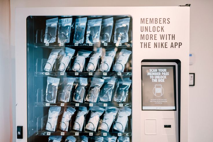 there is a vending machine that has many items in front of it and the words members unlock more with the nike app