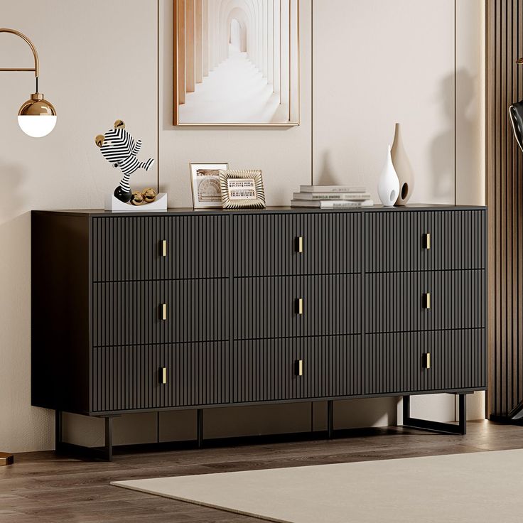 a black and gold dresser in a living room with pictures on the wall behind it