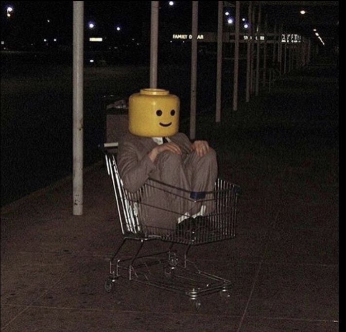 a man sitting in a shopping cart with a smiley face on it's head