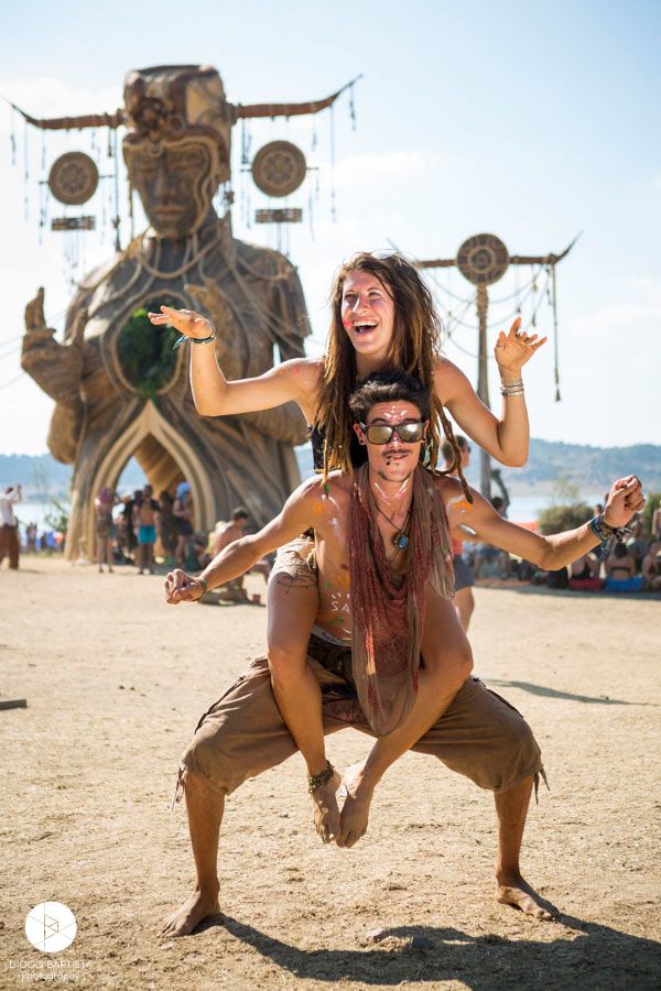 two people are playing with each other in front of a large statue at an outdoor event