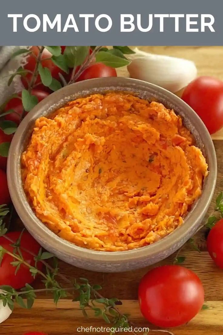 a bowl filled with tomato hummus next to some tomatoes