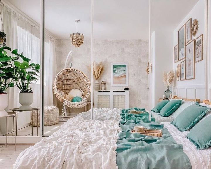 a bedroom with a bed, hanging chair and pictures on the wall above it is decorated in shades of blue and white