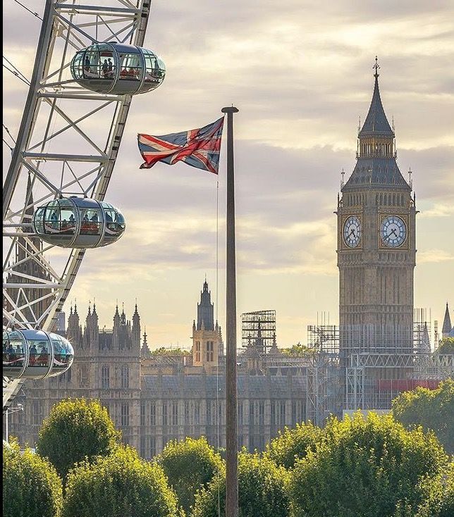 the big ben clock tower towering over the city of london, england with ferris wheel in foreground