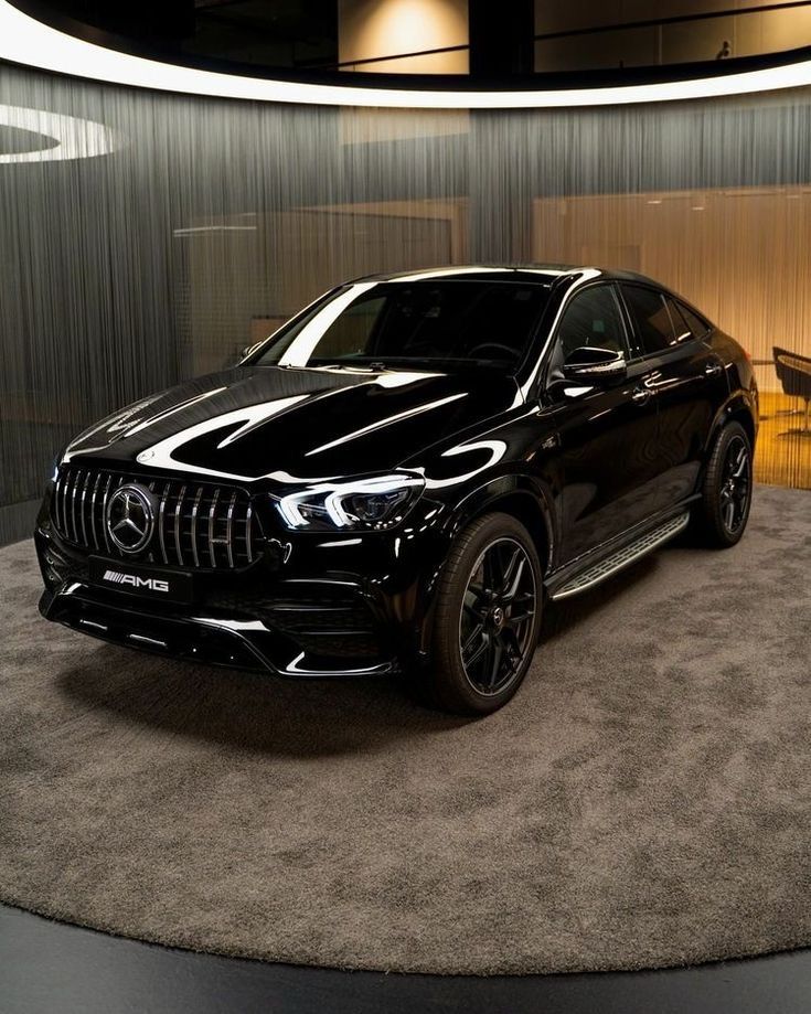 a black mercedes suv is on display in a showroom