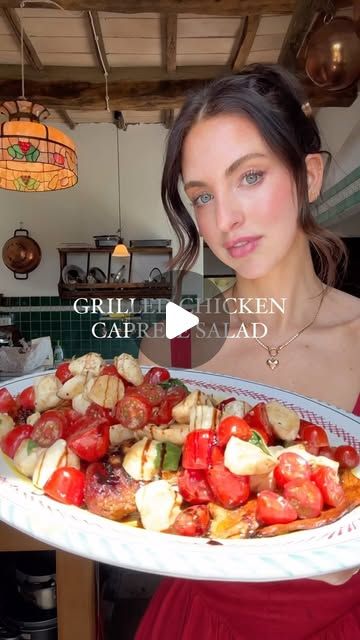 a woman in a red dress is holding a platter with food on it and looking at the camera