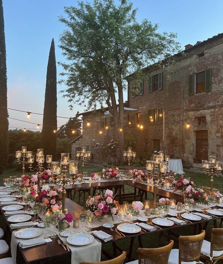 an outdoor dining area with tables and chairs set up for a formal dinner in the evening