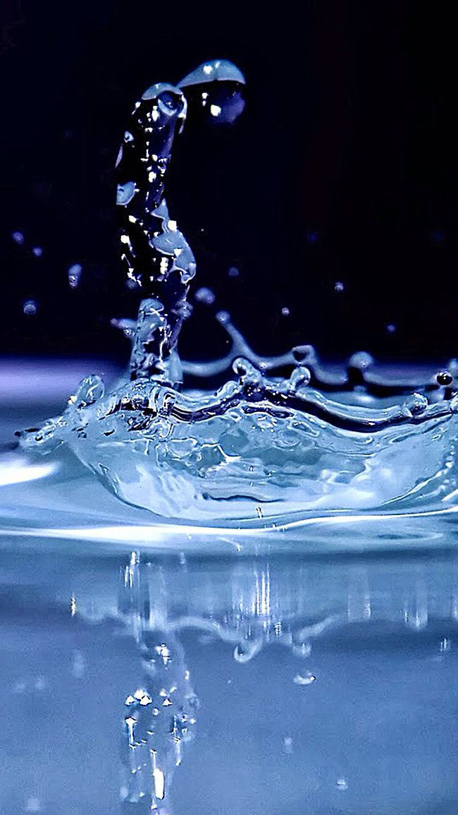 the water is splashing on top of the blue surface with small bubbles around it