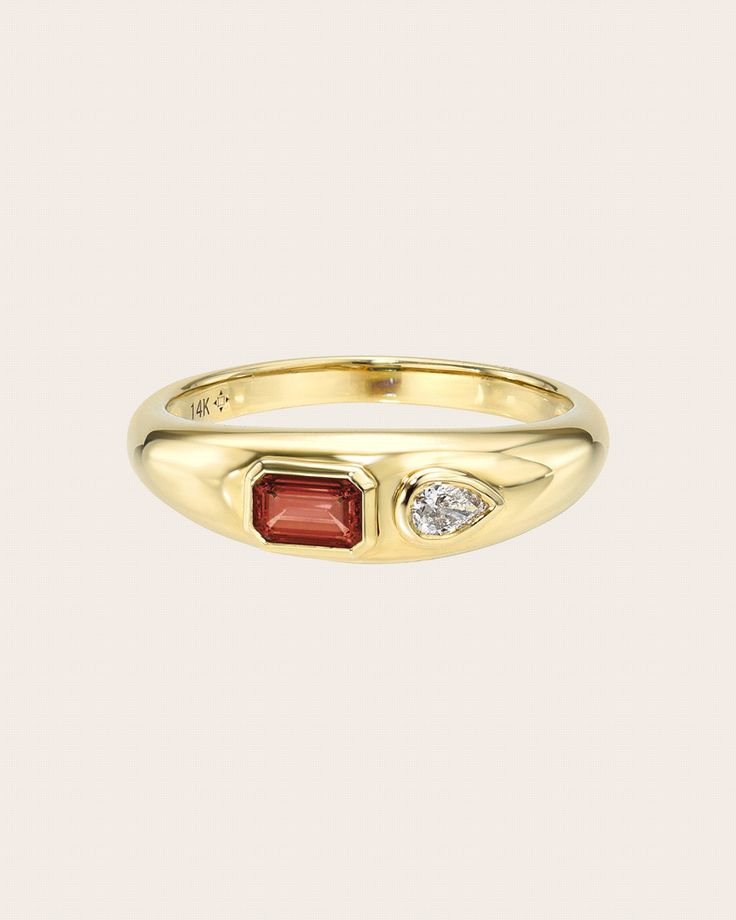 a yellow gold ring with two stones on the side and a diamond in the middle