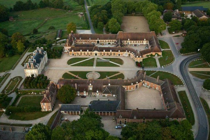 an aerial view of a large building surrounded by trees