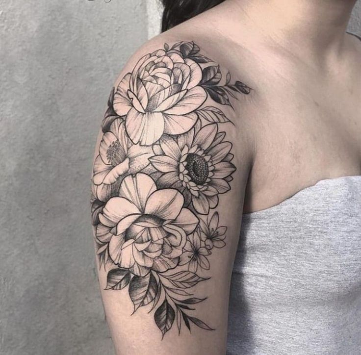 a woman's arm with flowers on it, and the back of her shoulder