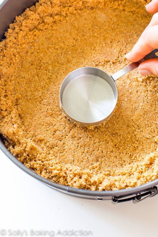 a person scooping sugar into a pan