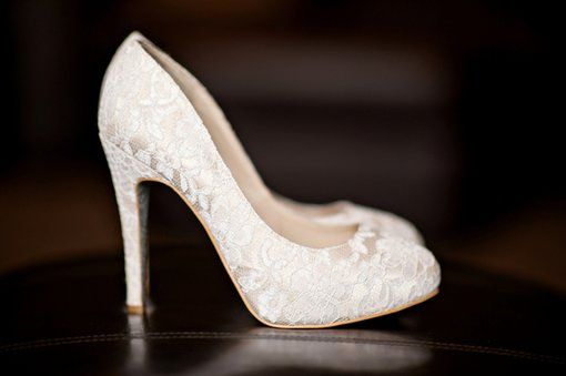 a white high heeled shoe sitting on top of a table