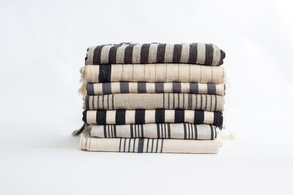 four towels stacked on top of each other in black and white striped patterns, with one folded