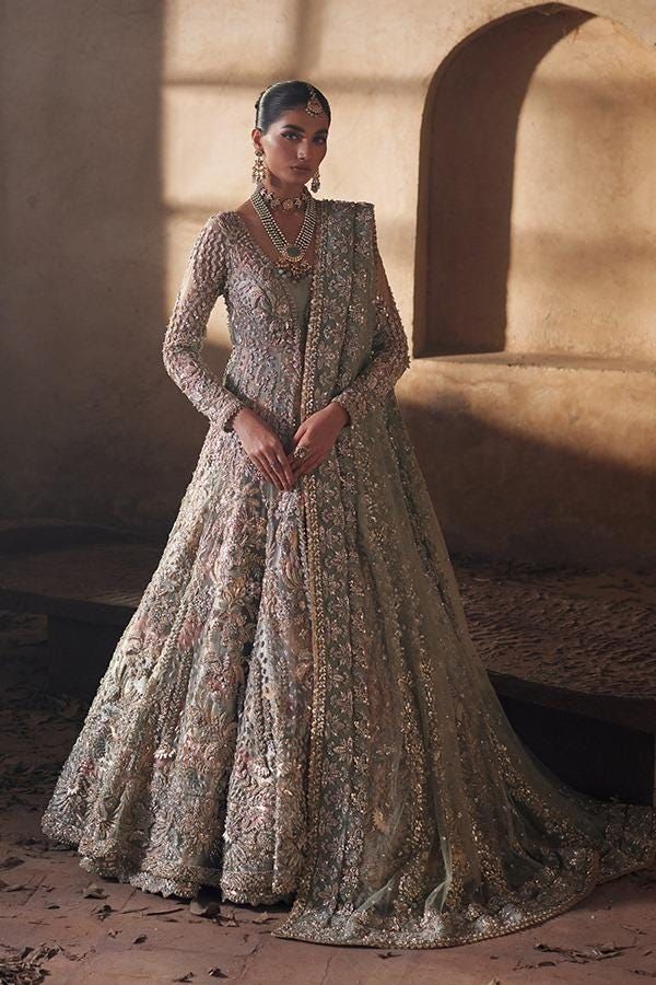 a woman in a long dress standing on a stone floor