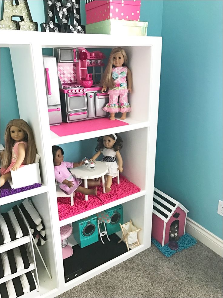 a doll house filled with lots of dolls and toys on top of bookshelves