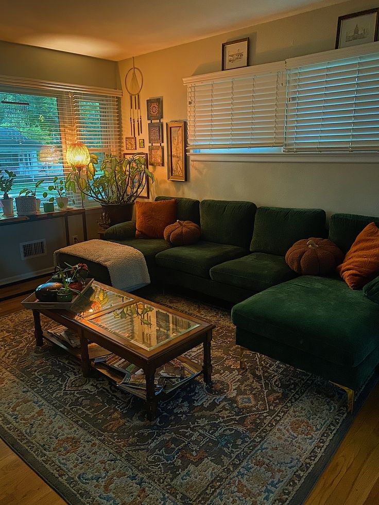 a living room filled with green couches and a coffee table on top of a rug