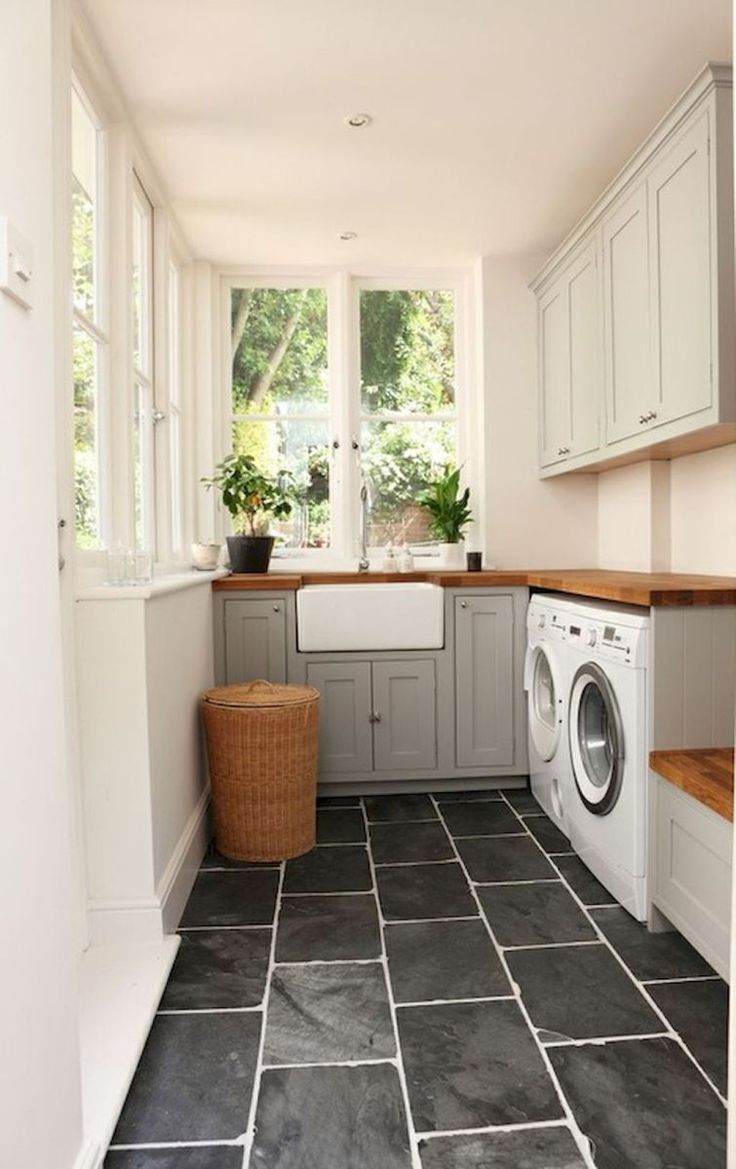 a washer and dryer in a small room with tile flooring on the walls