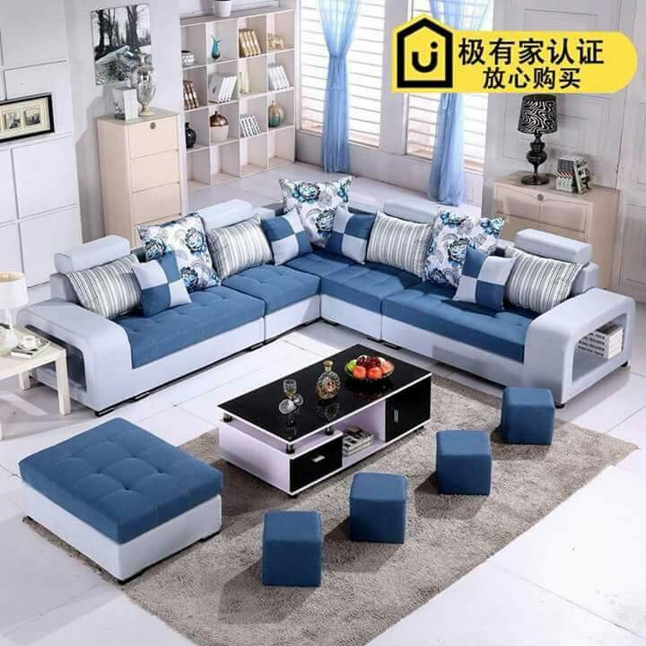 a living room with blue and white furniture in the corner, including a large sectional couch