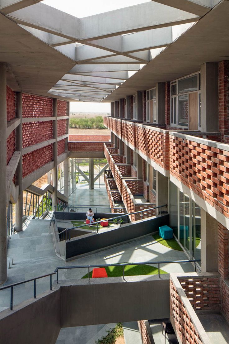 the inside of a building that has red bricks and green grass on the outside wall