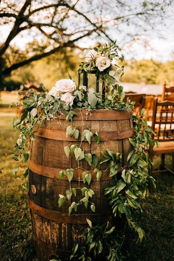 a wooden barrel with flowers and greenery on it