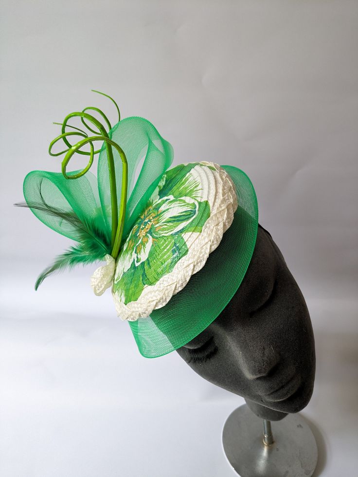 Add a touch of elegance to your outfit with this gorgeous green and ivory flower print fascinator. The beautiful crin brim and quill add a sophisticated twist to this classic piece. The fascinator is secured with an elastic band, making it easy to wear throughout the day without any discomfort.The green and ivory flower print provides an eye-catching contrast, adding a pop of color that is perfect for any occasion. Thanks to its versatile design, you can wear it on the side or at the center of y Bridal Fascinator, Ivory Flower, Ivory Bridal, Ivory Flowers, Flower Print, Fascinator, Flower Prints, Elastic Band, Caps Hats