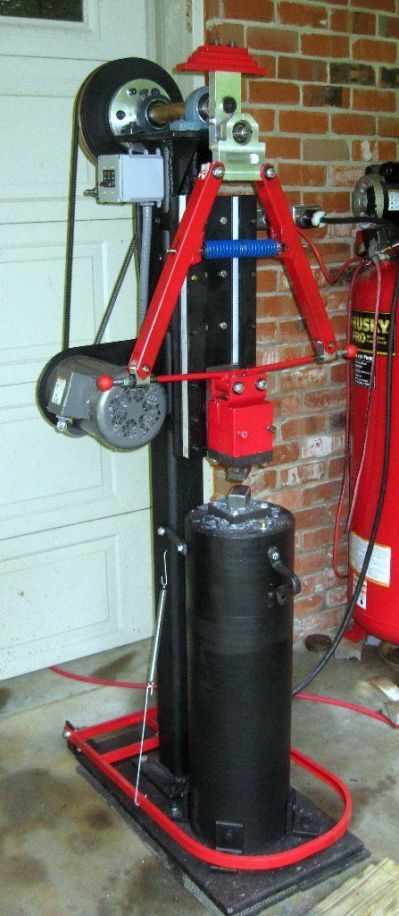 a red fire hydrant sitting on top of a metal stand next to a garage door