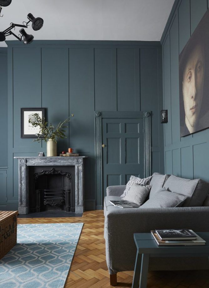 a living room with blue walls and wood flooring is pictured in this image from the front view