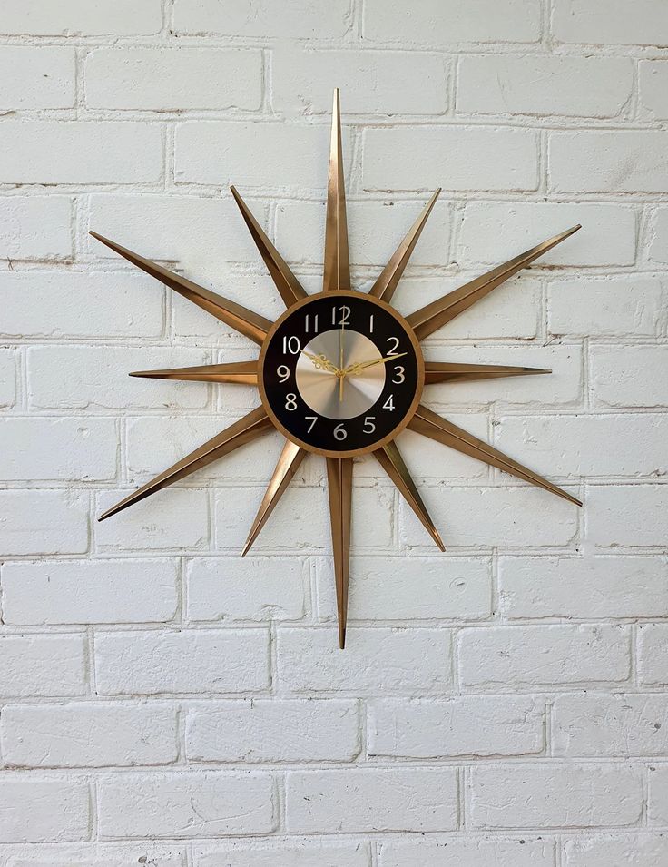 a clock mounted to the side of a white brick wall