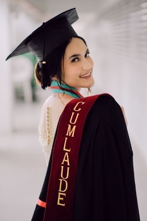 a woman wearing a graduation cap and gown with the word cumlaude on it