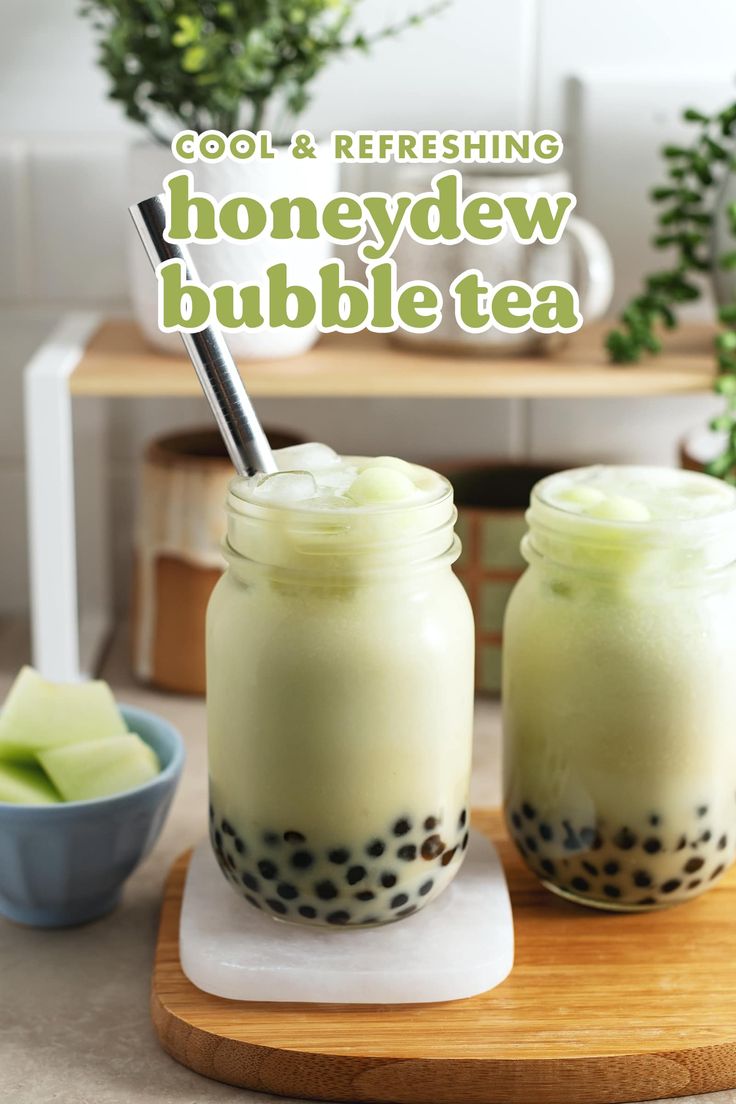 two mason jars filled with honeydew bubble tea on top of a cutting board