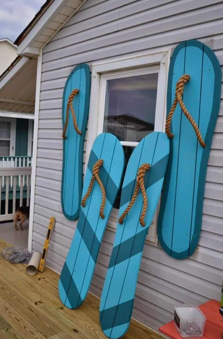 a pair of blue flip flops sitting on the side of a house