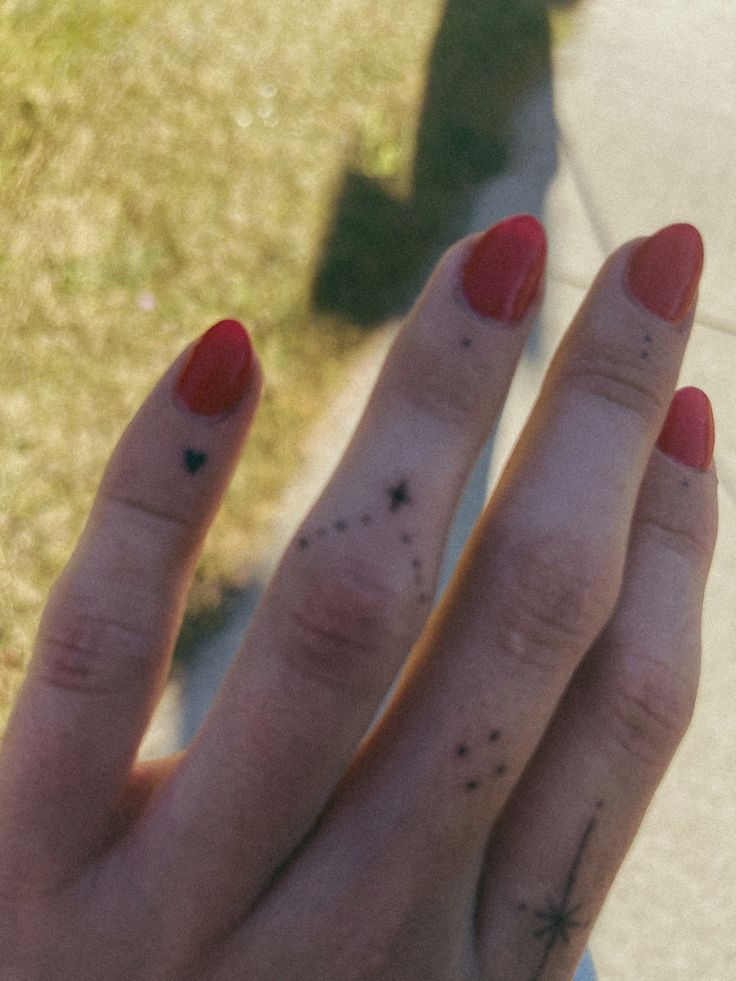 a woman's hand with red nail polish on it