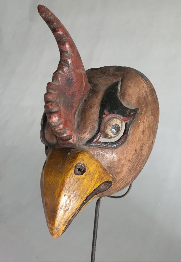 a wooden mask with a bird's head on it