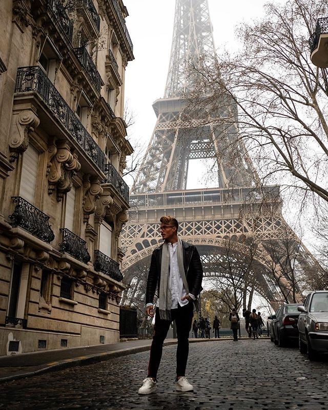 a man standing in front of the eiffel tower