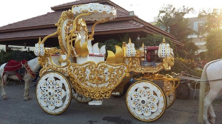 an elaborately decorated horse drawn carriage in front of a building