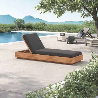 a wooden chaise lounge sitting next to a swimming pool