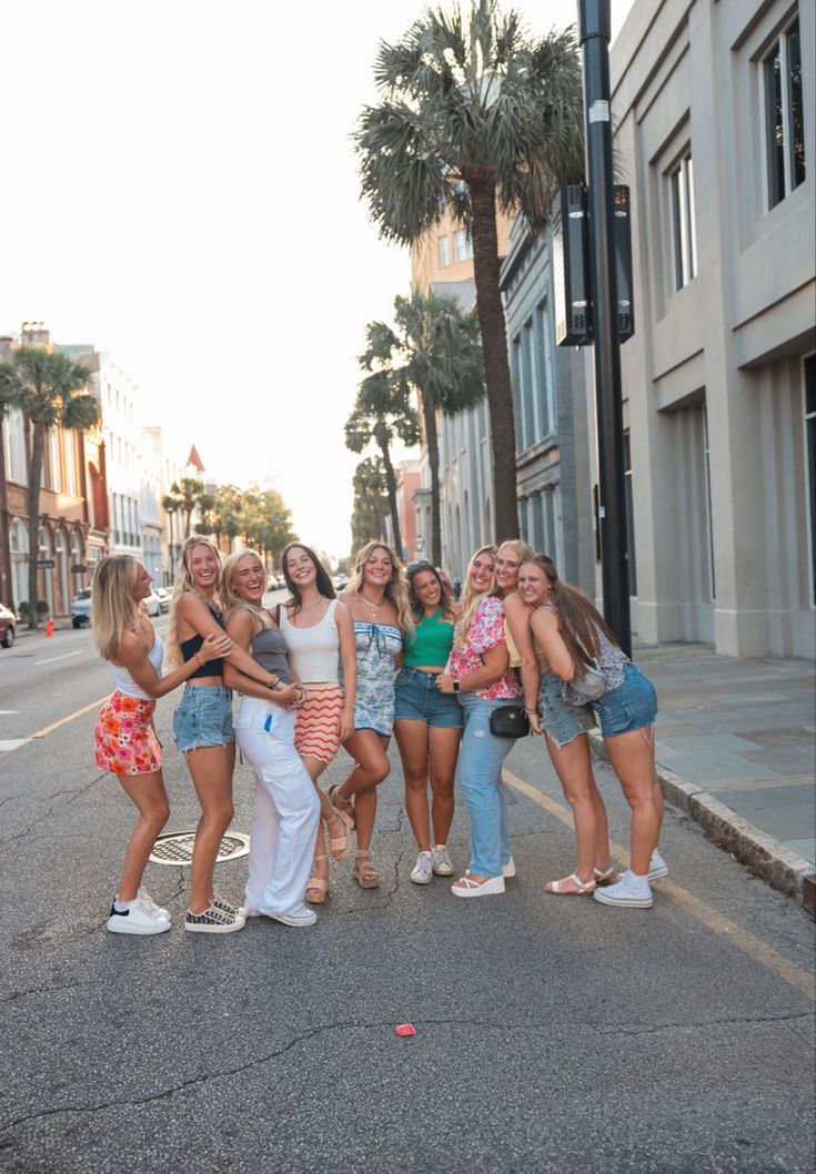 a group of young women standing next to each other on the side of a road