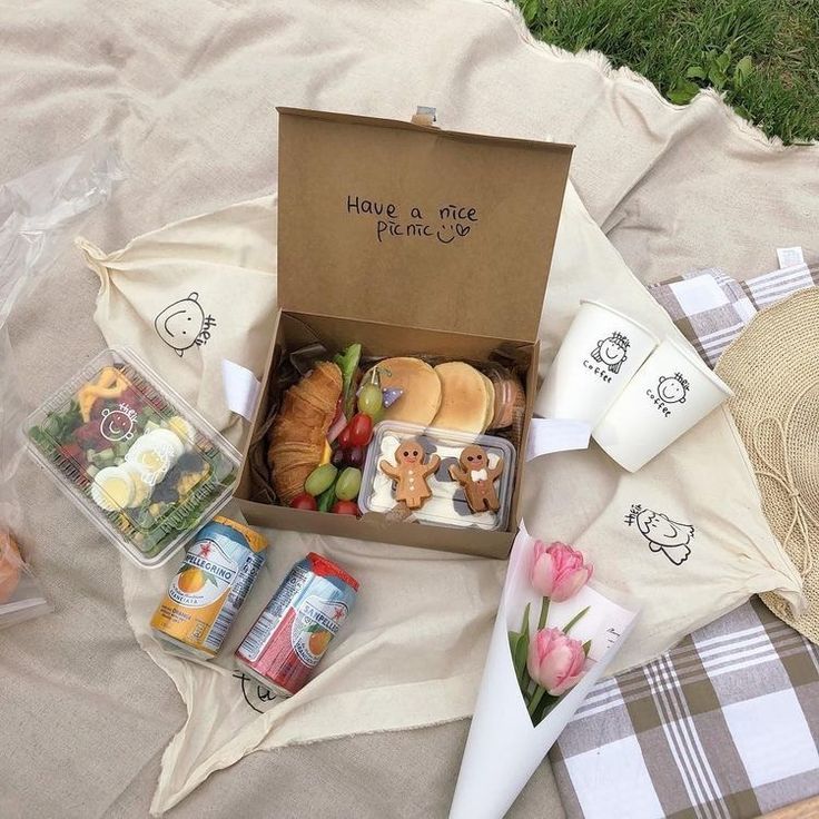 an open box filled with food sitting on top of a blanket next to other items