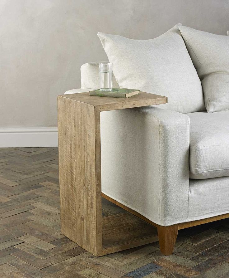 a white couch sitting on top of a hard wood floor next to a wooden table