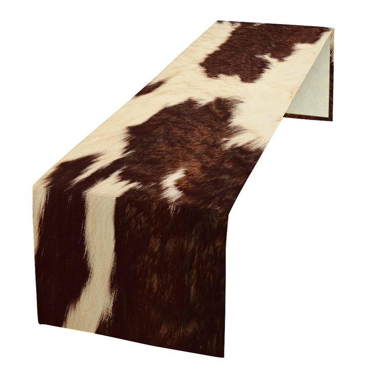 a cow print table runner is shown on a white background with brown and white spots