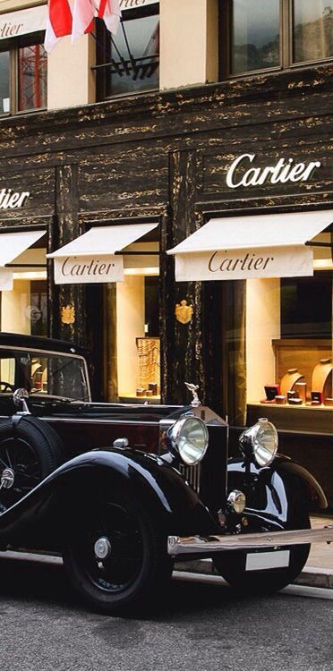 an old car is parked in front of a store